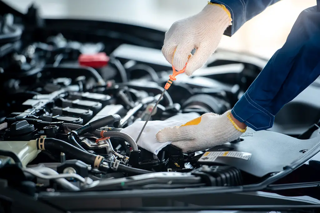 Asian car mechanic in an auto repair shop is checking the engine. For customers who use cars for repair services, the mechanic will work in the garage.